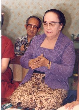 Foto berwarna Nyi Tjondrolukito sedang bertepuk tangan-keplok- sedang mengiringi alunan gending j...